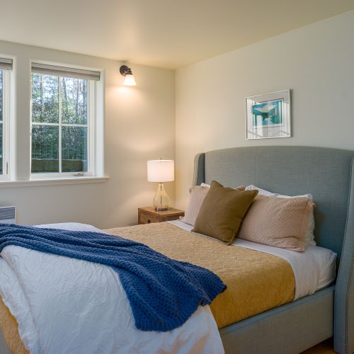 3rd bedroom with a plush queen bed, soft lighting, and peaceful garden views for a restful night’s sleep.