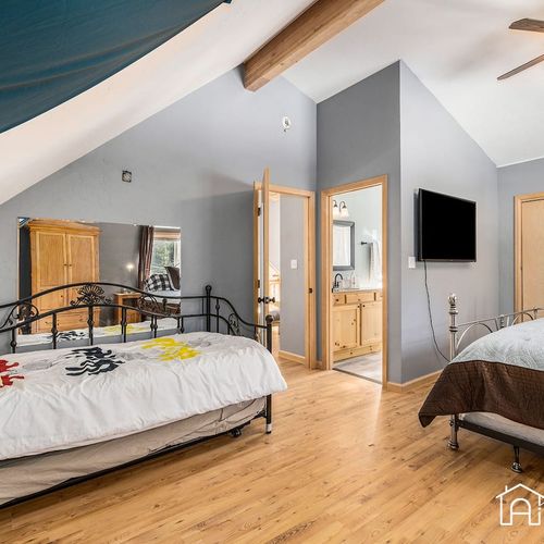 - versatile bedroom features a king bed and full bed with bright natural lighting
- ensuite bathroom and tv offer privacy and entertainment in one cozy setting
- perfect for families or friends who want to stay connected but comfortable