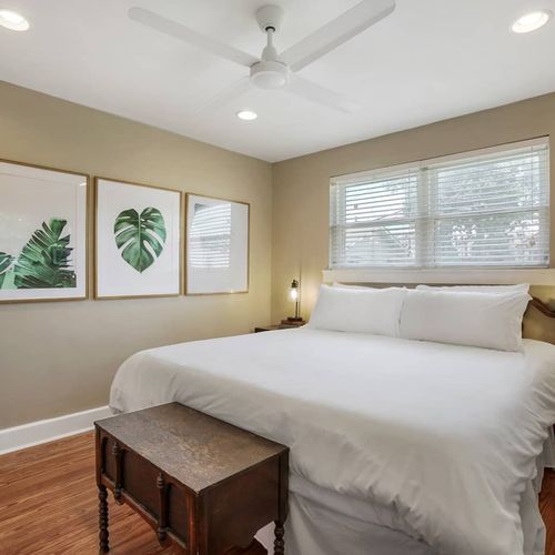 Retreat to this serene and stylish bedroom, featuring a plush king-sized bed and calming decor. With soft linens and a tranquil atmosphere, it's the perfect space to relax and recharge during your stay in New Orleans.