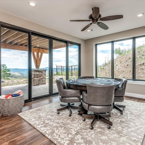 - let the games begin in this view filled entertainment space with natural light
- enjoy poker with a mountain backdrop framed by large glass doors and windows
- comfortable chairs, cozy textures, and sweeping views set the mood to play