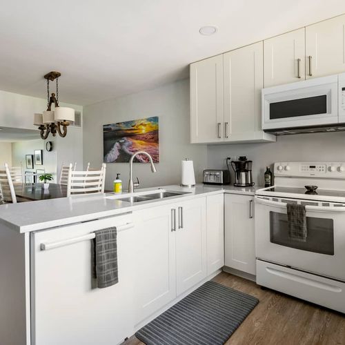 The kitchen is fitted with quartz countertops, shaker cabinets and full sized appliances.