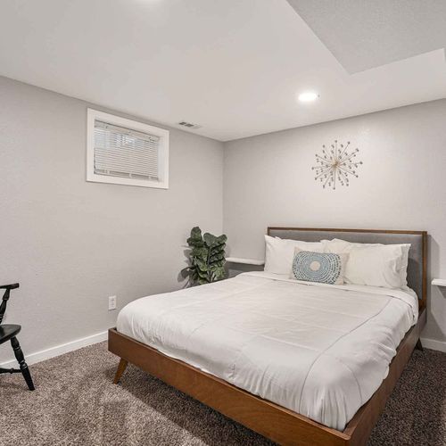 Downstairs offers two more bedrooms. This bedroom features a queen bed with soft linens and a comfortable mattress for a restful sleep.