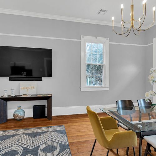 Charming dining space with exposed brick, chic chandelier, and a cozy fireplace setting the perfect ambiance for meals or gatherings.