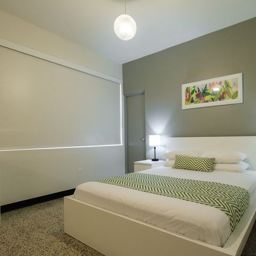 Experience a blend of contemporary style and cozy comfort in this inviting bedroom, featuring a comfortable bed and soothing ambiance for a relaxing stay