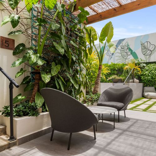 Relax in our stylish outdoor lounge, surrounded by greenery.