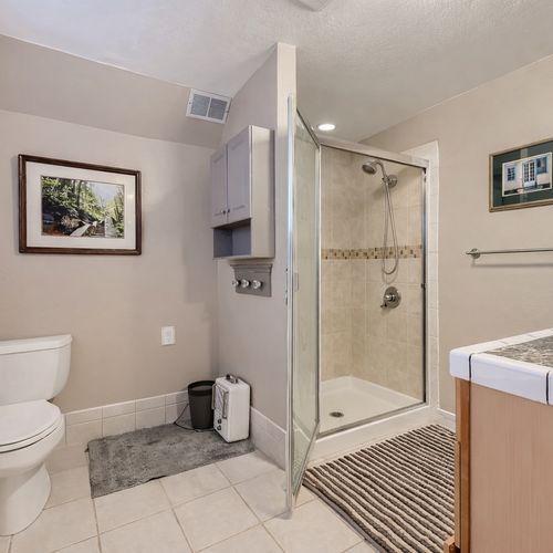 The upstairs hall bathroom is spacious with a stand-up shower and single vanity with drawers for extra storage.