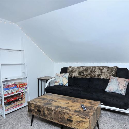 - charming attic lounge with plush futon, rustic coffee table, and ambient string lights
- fully stocked game shelf includes classics like clue, jenga, uno, and more
- perfect nook for winding down, reading, or late night board game sessions