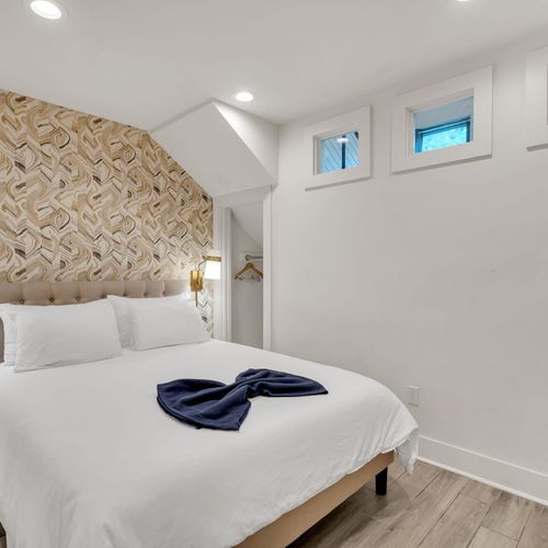 Serene bedroom w/ bold accent wall & soft lighting for a peaceful night's rest.