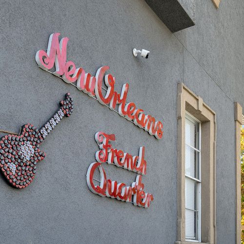 Celebrate the spirit of the French Quarter with this charming New Orleans-inspired wall art, complete with a vibrant bottle cap guitar.