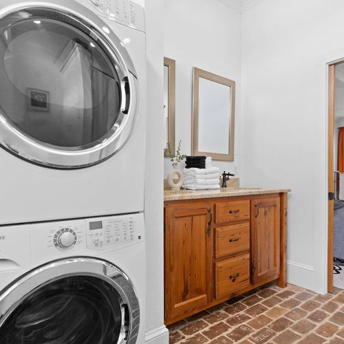 Stacked washer & dryer tucked in neatly — pack light & freshen up anytime.