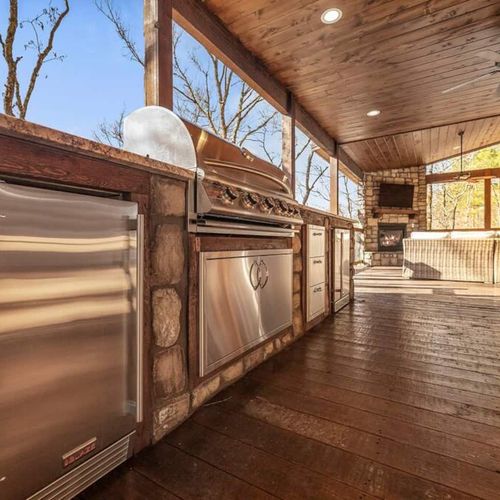 Built-in outdoor kitchen with sink, gas grill, ice maker, and mini fridge