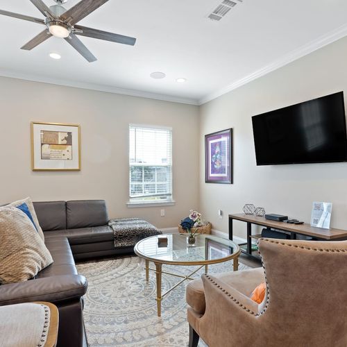 Bright living room w/ cozy seating & a wall-mounted TV for all your streaming nights in.