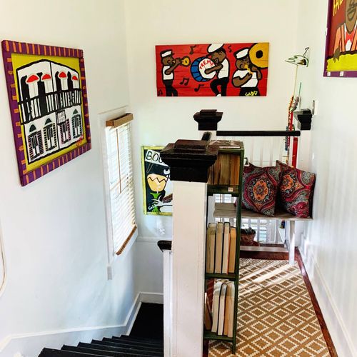 Vibrant wall art & a bold yellow door adding personality to the space.