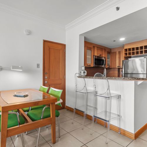 Chic kitchen and bar area featuring clear bar stools, perfect for casual dining and enjoying a drink.