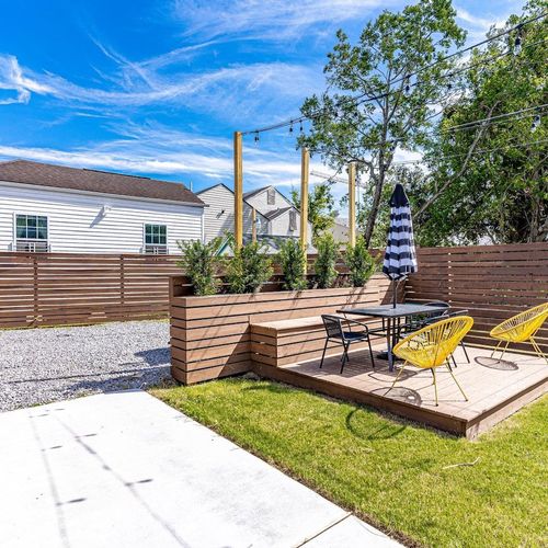 Backyard w/ parking, lounge seating & lush green space to relax & play.