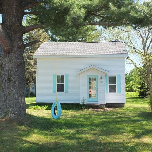 Exterior:  the front of the house with the tire swing on the large pine tree.