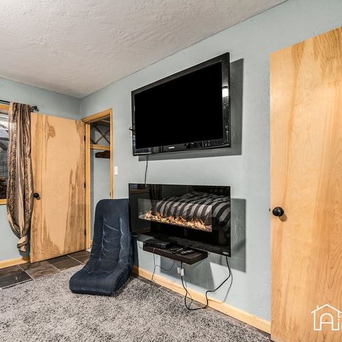 - cozy up with a movie night in this relaxed media nook featuring a mounted flat screen tv
- modern electric fireplace adds warmth and ambiance to the lower level lounge
- soft carpet and casual seating make this a perfect hangout space