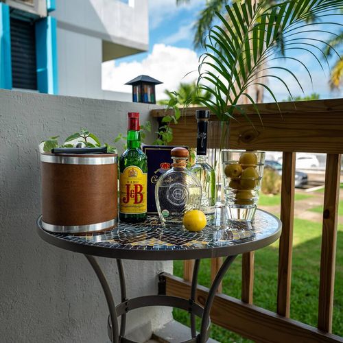 Set the scene for relaxation on your balcony! This cozy table is ready for your favorite drinks, offering a perfect spot to unwind and enjoy the pleasant surroundings.