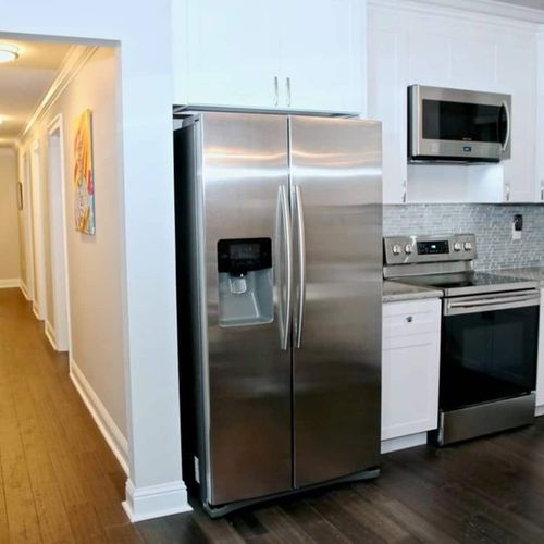 Stainless steel fridge & fully equipped kitchen ready for home-cooked meals.