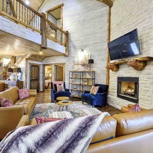A gathering space with high-end couches surrounding the indoor gas fireplace.