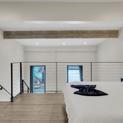 Sunlit bedroom w/ exposed beam & relaxed, airy vibe.