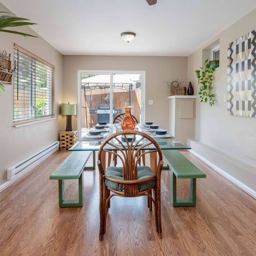 - spacious dining area with long benches and a cozy rattan chair for hosting
- surrounded by windows, plants, and modern wall art for a bright ambiance
- opens to the backyard grill area, ideal for indoor-outdoor gatherings