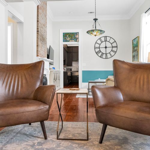 Leather armchairs bathed in warm light — sink in & unwind.