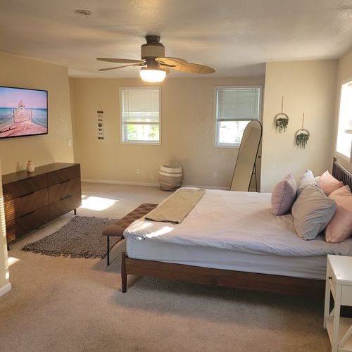 Bedroom #1:  the luxurious upstairs bedroom with an ensuite bathroom, a tv,  a closet, mini-split a/c unit, and private balcony