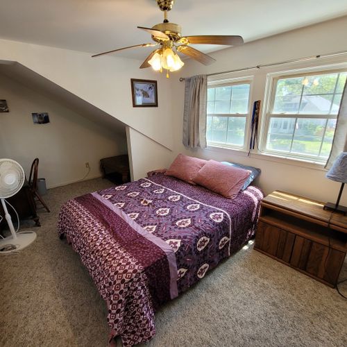 Bedroom #1 ( second floor):  large master bedroom with a queen-size bed, closet, vanity, ceiling fan, pedestal fan, and nightstand.