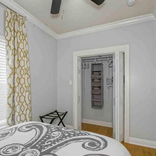 Bedroom w/ smart TV, luggage rack, & closet organization — designed for a stress-free stay.