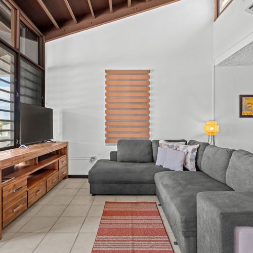 Feel at home in our cozy living space, complete with a comfy sofa, modern TV setup, and plenty of natural light for a serene ambiance.