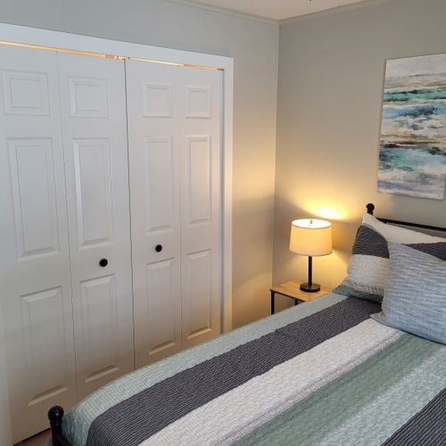 Bedroom #2:  features a queen-size bed, ceiling fan, nightstand, lamp, large closet, and 2 chairs.