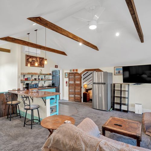 Open-concept living area w/ exposed beams & a bright, airy feel.