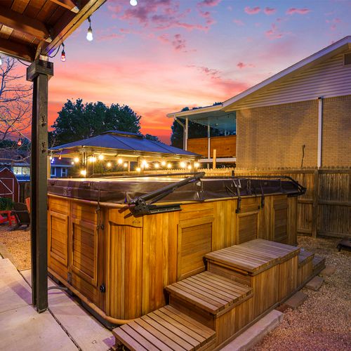 The spa pool shines invitingly under the soft glow of string lights at night.