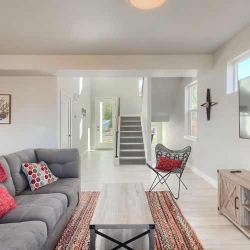 - cozy living space with accent pillows and rug leads into the bright open entryway