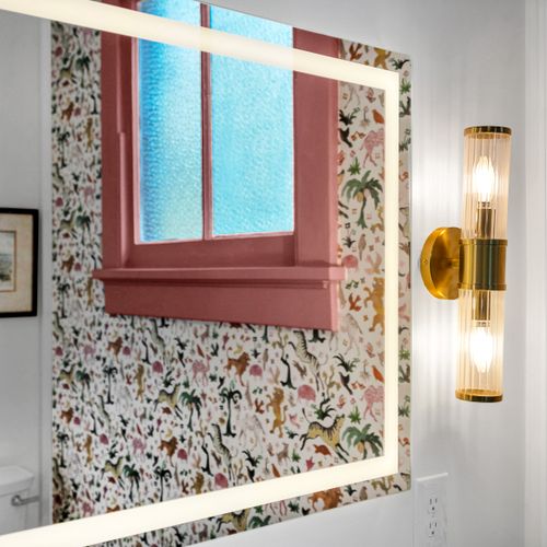 Playful bedroom w/ floral wallpaper & warm gold lighting for a boutique-hotel feel.