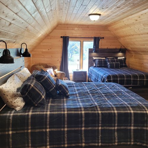 BEDROOM #3 (SECOND FLOOR BUNK ROOM ABOVE GARAGE):  Features 2 queen-size beds, a comfy chair, wall A/C unit, wall heater, electric fireplace, 2 nightstands, a dresser, mini refrigerator, and live streaming television (via Sling).