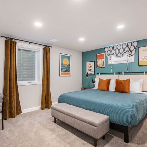 The large downstairs third bedroom boasts stunning blue hues and modern decor, creating a stylish and inviting retreat for guests.