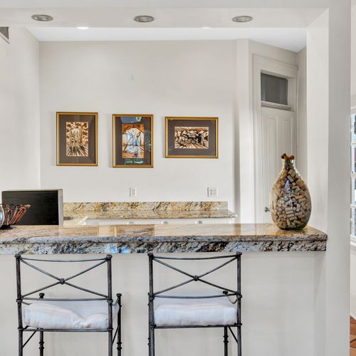 Chic bar seating with granite counters and unique artwork.