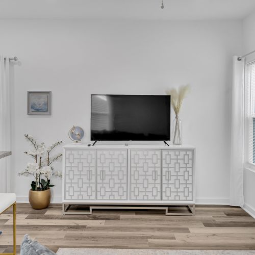 Unwind with your favorite shows on this sleek, modern entertainment console, surrounded by tasteful decor and bright natural light.