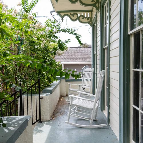 Charming front porch with cozy rocking chairs—perfect for sipping coffee while enjoying the New Orleans breeze.