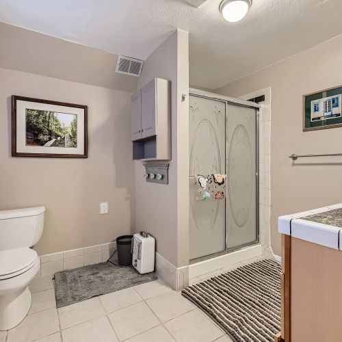 The upstairs hall bathroom is spacious with a stand-up shower and single vanity with drawers for extra storage.