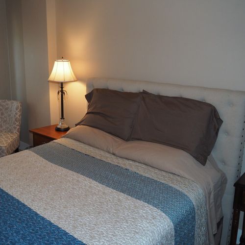 Bedroom #1:  features a queen-size bed, mirror, nightstands, lamps, dresser, chair, and television.