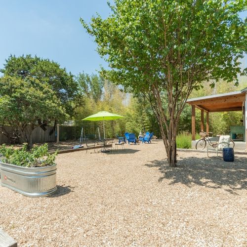 The courtyard area around the side of the main house and in front of the Cottage with a fenced area to the side.