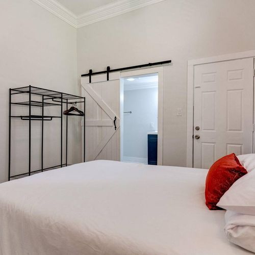 Serene master bedroom w/ a barn door leading to the en suite — a peaceful retreat to come home to.