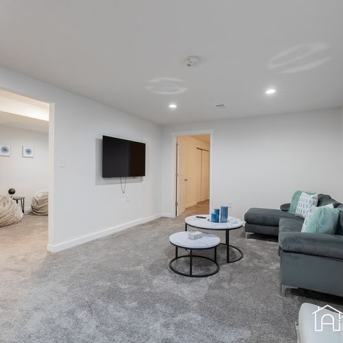 The downstairs living room features a cozy section, accent seating and a 55" smart tv to stream all your favorite content.