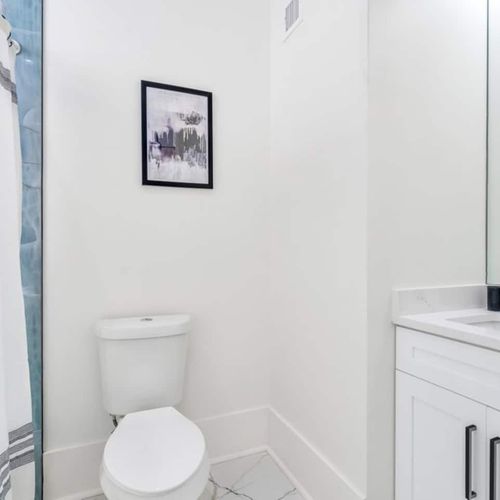 Upstairs full bathroom w/ double sink vanity & modern black accents.