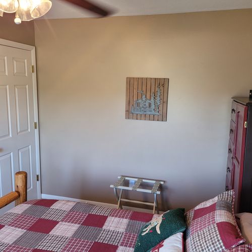 BEDROOM #1 (FIRST FLOOR):  Features a beautiful queen-size bed, ceiling fan, dresser, nightstand, lamp, closet, and makeup table with chair and mirror.