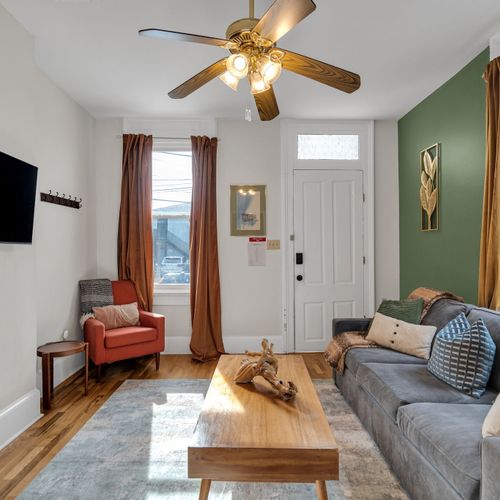 Inviting living room w/ warm tones & comfortable seating — kick back & unwind.