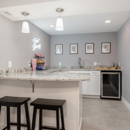 The lower level comes fully-equipped wet bar with countertop seating, complimentary snacks, and mini fridge, complete with a dapper neon sign.